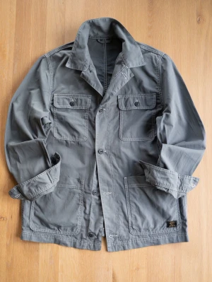 Grå/grön Chore Jacket med stora fickor - Stilren grå overshirt i bomull med fyra stora fickor framtill och tydliga vita sömmar. Klassisk krage och knäppning med knappar. Perfekt lager-på-lager-plagg för dig som gillar en avslappnad men snygg look.
