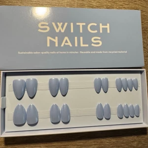 Switch Nails ljusblå almond press-on - Snygga press-on naglar från Switch Nails i modellen 'Out of the Blue'. Naglarna har en kort almondform och kommer i en mjuk ljusblå färg. Tillverkade av återvunnet material och kan återanvändas. Perfekt för dig som vill ha salongskänsla hemma på nolltid.