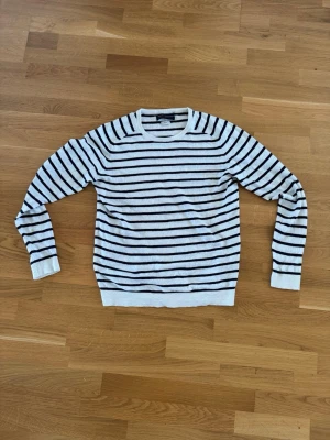 Randig stickad tröja Jack & Jones - Säljer en stilren stickad tröja från Jack & Jones i vitt med svarta horisontella ränder. Tröjan har rund halsringning och ribbade muddar vid ärmslut och nederkant. Perfekt för dig som gillar klassisk och enkel design. Nypris 700kr