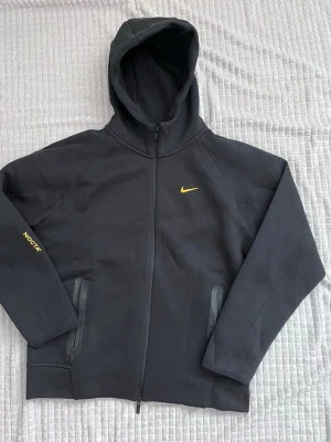 Nocta kofta - Hej! Jag säljer en superfin och skön Nike Nocta kofta. Den är helt ny och oanvänd, men tyvärr passar den inte mig. Den är en 2XL, men funkar även bra för en 1XL. Hör av dig om du är intresserad! 