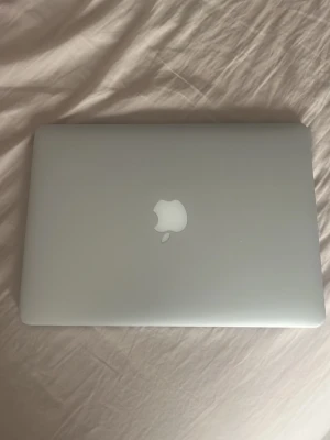 MacBook i silver från Apple - Säljer en stilren MacBook i silver med klassisk Apple-logga på locket. Datorn har en stor touchpad, svart tangentbord och aluminiumchassi. Perfekt för studier, jobb eller kreativt skapande. Lätt och smidig att ta med överallt. Batterihälsan är dålig, därför lågt pris 