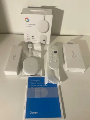 Google Chromecast med Google TV HD - Säljer en vit Google Chromecast med Google TV HD. Medföljer fjärrkontroll, strömadapter, USB-kabel och originalkartong. Streama enkelt från appar som YouTube, Netflix och Disney+. Smidig och modern design i plast, perfekt för att göra din TV smartare.