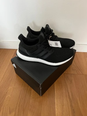Adidas Ultra Boost svarta sneakers - Säljer ett par helt nya svarta Adidas Ultra Boost sneakers, Box ingår, perfekta till sommaren, skriv om ni är intresserade.