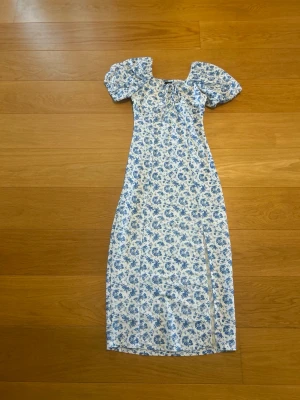  Gina Tricot blommig klänning XXS – fint skick 🌸 -  Säljer denna superfina blommiga klänning från Gina Tricot i storlek XXS. Klänningen har ett romantiskt blåvitt blommönster, puffärmar och en fin slits framtill. Perfekt till sommaren, midsommar, semester eller andra festliga tillfällen.   Endast använd vid max 3 tillfällen  Storlek XXS  Fint skick  Märke Ginatricot.    En mindre missfärgning har upptäckts och finns med på bild. Åker troligtvis bort med en andra tvätt. Kommer från djur och rökfritt hem.  Pris: 179 kr (eller bud vid snabb affär)