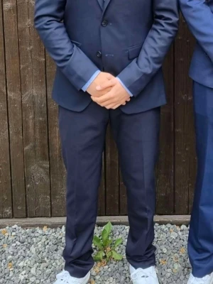 Mörkblå kostym från Riley Slim Fit - Snygg mörkblå kostym från Riley i slim fit-modell. Klassisk kavaj med knappar och matchande byxor. Perfekt för dig som vill ha en stilren och modern, den är bara använd 1 gång och sälj för att den inte används går även att köpa byxorna eller kavajen separat.