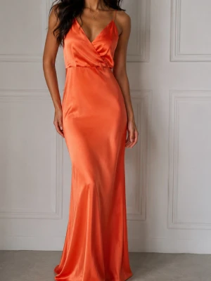 Lång klänning strl L   - Säljer en lång, elegant klänning i orange satin look  med smala axelband. Klänningen har en djup v-ringning och figurnära passform som ger en snygg siluett. Perfekt för dig som vill sticka ut med en färgstark look.