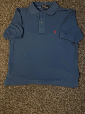 Ralph lauren pike - Klassisk blå pikétröja från Polo Ralph Lauren med korta ärmar och krage. Dock tröjan är ljus blå och lite ljusare en på bilderna så ni vet