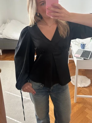 Svart v-ringad blus med puffärm - Säljer denna blus i silkesmaterial. St s superfin och knappt använd🥰🥰