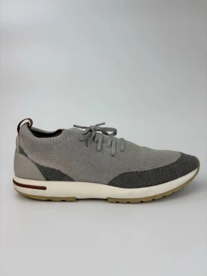 Loro piana flexy walk - Snygga grå sneakers med stickad ovandel och snörning. Skorna har en vit sula med beige detaljer och en mörkare grå sektion vid tån och hälen. Perfekta för en avslappnad och modern stil. Ovandelen är i textil för extra komfort.