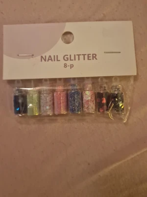 Nail Glitter 8-pack mixade färger - Ett set med 8 små burkar nagelglitter i olika färger och former, perfekt för att skapa kreativa och unika nageldesigner. Innehåller glitter i blått, grönt, vitt, rosa, lila, silver samt dekor i hjärt- och stjärnform. Passar till nail art och dekoration.