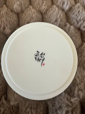 Radiance Cleansing Balm Beauty of Joseon - Radiance Cleansing Balm från Beauty of Joseon i en rund, vit plastburk med stilren design och koreansk text på locket. Perfekt för att ta bort smink och rengöra huden på djupet. Använt en gång 