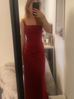 Vinröd långklänning i satin - Superfin röd klänning som kan användas både till bal eller finare tillfällen, den går ända ner till marken på mig och jag är 157 cm, svårt att se på bilden men man kan justera midjan då det är snörning i ryggen. Kostade 1000 kr när jag köpte och aldrig använt, priset kan förhandlas💛