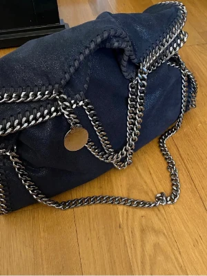 Stella McCartney väska  - Säljer min Stella väska som är marinblå och mellanstor!! Nypris mellan 8000-12000, minns ej. Defekterna visas på de två sista bilderna. Att kedjan har rostat lite syns endast i blixt och inte i dagsljus som ni kan se på bilderna!! Dustbag medföljer💞💞