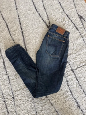 Nudie Jeans - Snygga mörkblå jeans från Nudie Jeans med skön tvätt.  Slim fit, storlek 26/32. Skriv vid minsta fundering! 