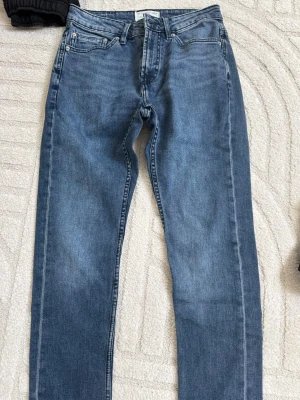 Blå jeans från Pull&Bear - Snygga blå jeans från Pull&Bear i klassisk femficksmodell. Jeansen har raka ben och normal midja, tillverkade i denim med lätt tvättad look. Perfekta för en avslappnad och trendig stil. Barn storlek eur 38
