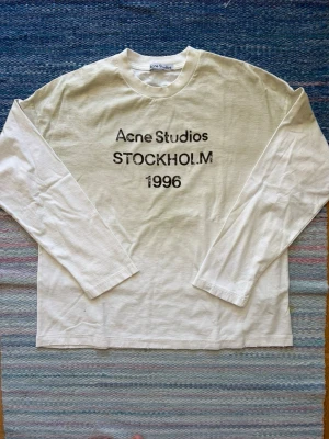 Vit Acne Studios longsleeve - Helt ny vit acne studios longsleeve i storlek M, passformen är mer oversized än vanliga märken. Köpt från acne studios hemsida, kvitto finns. Hojta till om du har några frågor!
