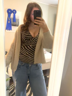 Zebramönstrad body - Superfin zebramönstrad body i stretchigt tyg med djup ringning – passar perfekt både till fest och vardag med jeans eller kjol. Storlek: M normal storlek  Skick: Mycket bra, använd få gånger Färg: Svart/vit zebra 