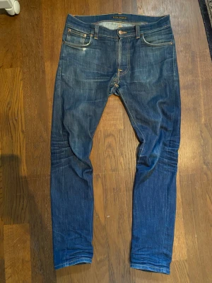 Nudie jeans Lean Dean  - Snygga mörkblå jeans från Nudie Jeans med klassisk femficksdesign och orangea sömmar. Jeansen har smal passform och är tillverkade i denim med lätt slitning och fina detaljer på bakfickorna.