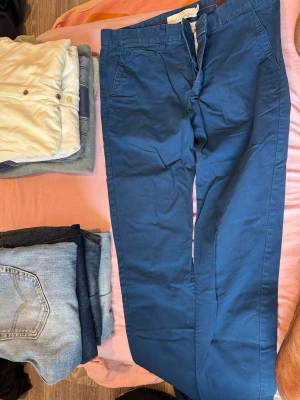 Blå chinos med klassisk passform - Snygga blå chinos med rak passform och diskreta sidfickor. H&M passar S/m