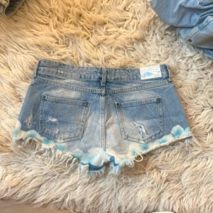 J17 Lågmidjade jeansshorts färgsplatter - Midja ca 40 cm❤️Första bild lånad men exakt samma modell! Mina är dock något mörkare och med blå färgsplatter istället för rosa