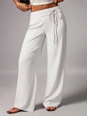 Vita vida byxor med knytband - Vita byxor med midwaist och bred resår samt knytband framtill. Byxorna har en avslappnad passform med vida ben och är gjorda i ett mjukt, stretchigt material som känns riktigt bekvämt. Perfekt för en chill och trendig stil. Sköna men tyvärr för korta för mig som är 177, har ett tunt och luftigt material, aldrig använt! Är storlek L men är små i storlek så rekommenderar för storlek M så dem hänger lite snyggt på midjan 