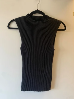 Svart ribbad ärmlös topp från Lindex - Snygg svart ärmlös topp från Lindex med ribbad struktur och hög hals🥰🥰