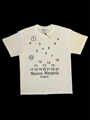Maison Margiela t-shirt - Säljer denna riktigt snygga och helt nya vita T-shirten med tryck i storlek S. Perfekt nu inför sommaren! Hör av er ifall ni har några frågor! ⭐️