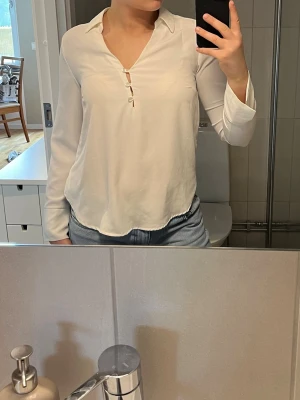 Vit blus med knappar och krage - Stilren vit blus krage. Blusen har lång ärm och lätt v-ringad halsringning. Tillverkad i ett mjukt, tunt tyg som.💞