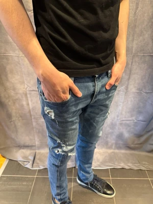 Replay jeans - Replay anbass jeans med otroligt feta slitningar i size 32/34. Modellen är 183cm, bra skick (förutom bild 5, då hålet är sytt). Nypris på NK= 1500kr, mitt pris= 299kr 