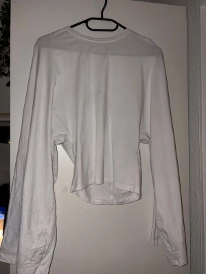 Vit långärmad topp - Vit långärmad tröja från lager, den går in i midjan och är bredare i armarna. I storlek S i väldigt bra skick💕
