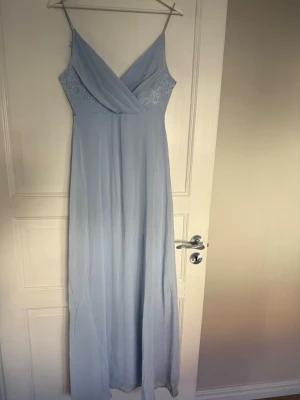 Ljusblå balklänning från Bubbleroom - Säljer en fin ljusblå balklänning från Bubbleroom. Klänningen har en v-ringning fram och baktill med en fin spets detalj. Är använd vid två tillfällen men är i bra skick🩵
