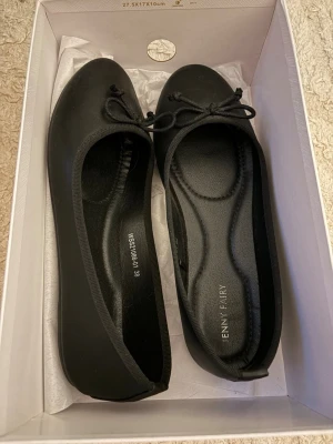 Ballerinaskor  - Stilrena svarta ballerinaskor med rund tå och dekorativ rosett framtill. Skorna har en klassisk siluett och är tillverkade i ett slätt material med mjuk innersula för extra komfort. Använda 1 gång eftersom de visade sig vara lite stora