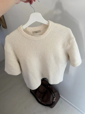 Vit stickad tröja från Gina - Vit stickad tröja med trekvarts ärm från Gina i small.
