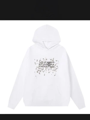 Maison Margiela hoodie  - Vit hoodie med huva från Maison Margiela. Framsidan har ett unikt tryck med siffror och gråa stänk, samt klassisk känguruficka. Perfekt för dig som gillar streetwear och vill sticka ut med en stilren look. Finns i m och s