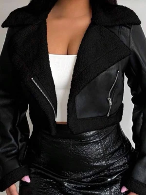 Svart croppad skinnjacka med fuskpäls - Snygg svart croppad skinnjacka med breda slag och detaljer i fuskpäls. Jackan har dragkedjor framtill och på fickorna, samt en cool, glansig finish. Perfekt för dig som vill ha en edgy och trendig look.