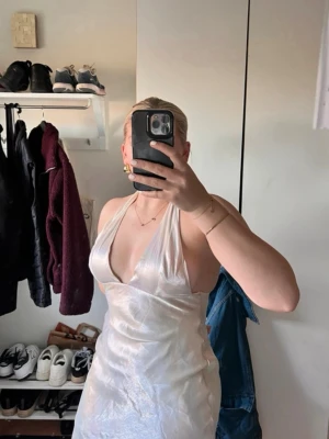 Balklänning  - Säljer en vit (med lite färginslagk) långklänning med en så fin rygg och djup v-ringning. Klänningen är ärmlös och har ett elegant, skimrande material som ger en lyxig känsla. Perfekt till balen. Lapp finns kvar, från ZARA storlek M