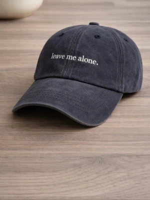 Svart keps med text - Snygg svart keps i bomull med böjd skärm och broderad vit text framtill som säger 'leave me alone.'. Klassisk sexpanel-design med ventilationshål och justerbar rem bak. Perfekt för dig som vill ha en chill och avslappnad stil.