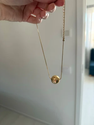 Guldigt halsband från Nelly - Guldigt halsband med guld detalj från Nelly