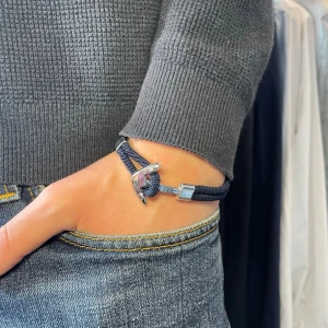 Marinblått armband med ankardetalj - Snyggt marinblått armband med en metallfärgad ankardetalj som lås. Armbandet har en flätad textilrem och coolt, stilrent utseende som passar perfekt till jeans och casual outfits. Justerbar längd för bästa passform.