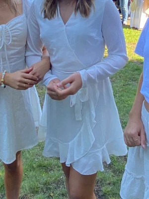 Vit klänning - En vit klänning som passar perfekt som studentklänning/konfirmationsklänning! Endast använd en gång och därav mycket bra skick. Knyts i midjan och har en osynlig dragkedja längst ena sidan. Storlek 38🤗