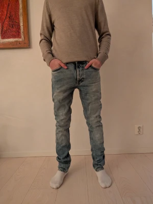 Ljusblå nudie jeans - Säljer ett par feta ljusblå nudie jeans då de för stora för mig. 9/10 skick (aldrig använt). Stl-27:32. Modellen är slim. Ny pris är 1600