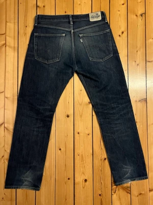 Levi's silvertab jeans straight fit 31 32 - Unika Levi's silvertab jeans i mörkblå denim med straight i passform. Storlek 31 32. Jeansen har silverfärgade nitar, knappgylf och tydliga sömmar på bakfickorna. Materialet är robust bomullsdenim med lätt slitningar för en avslappnad look. 