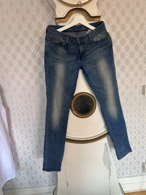 jeans från Levi's demo curve - Snygga blå slim fit jeans från Levi's med klassisk femficksdesign och slitningar framtill och baktill. Jeansen har normal midja och raka ben, tillverkade i denim med lätt stretch för extra komfort. Perfekta för en avslappnad och trendig look.