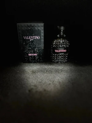 Valentino svart parfymflaska -  Pris original 970kr.Snygg parfymflaska från Valentino i svart glas med nitar och en cool, strukturerad yta. Flaskan har en svart etikett med rosa text och ett unikt, edgy utseende som sticker ut på. Endast använd några gånger, väldigt bra skick. Kommer med originalbox.  Flaskan är väl omhändertagen och fungerar perfekt.  Perfekt doft för dig som gillar en elegant och lite mörkare vibe. Pris kan diskuteras 
