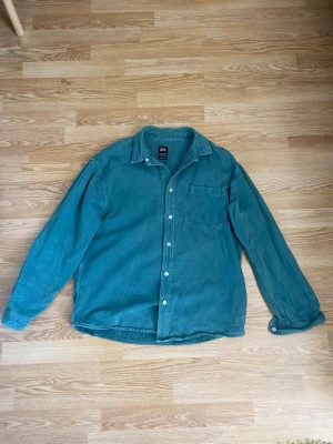Overshirt från Zara - Snygg blågrön skjorta från Zara. Lite grövre material med snygga silverknappar och en bröstficka. Storlek M