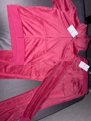 Rosa Juicy Couture - Säljer ett rosa sett från juciy couture som är helt nytt, säljer den pågrund av att den var lite för stor, storleken är 14-15 år och 164-170 cm lång skulle säga att den passar ungefär som storlek S, settet är oanvänd och det finns inget fel på det. 