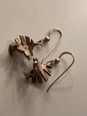 Unika örhängen i  äkta silver - Säljer ett par coola örhängen i äkta silver med en abstrakt, geometrisk design. Hängande modell med krok och texturerad yta som ger en rå och konstnärlig känsla. Äkta silver i en råare form! 