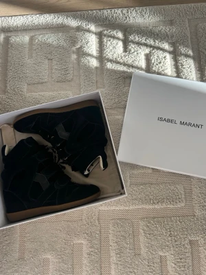 Svarta Isabel Marant sneakers med kilklack - Svarta Isabel Marant. Skorna är i mocka och läder. Använd endast inomhus 2 gånger.