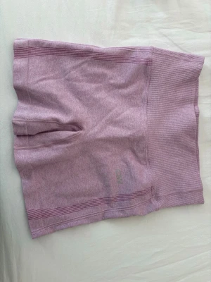 Ljusrosa seamless shorts från ICANIWILL - Säljer ett par ljusrosa seamless shorts från ICANIWILL med hög midja och ribbade detaljer upptill. Perfekta för träning eller chill dagar. Materialet är stretchigt och mjukt för maximal komfort.