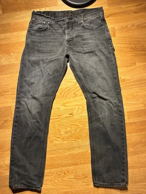 Nudie jeans ”Steady Eddies” W34 L32 - Authentic Nudie Jeans Steady Eddie in a clean grey wash. Regular tapered fit — comfortable with a modern look.  * Size: W34 L32 * Fit: Steady Eddie (regular tapered) * Condition: (add: very good/good) * Color: Grey wash * Organic cotton denim * Classic Nudie quality + leather patch  Easy to style, perfect everyday jeans.  Fast shipping. Open to offers.